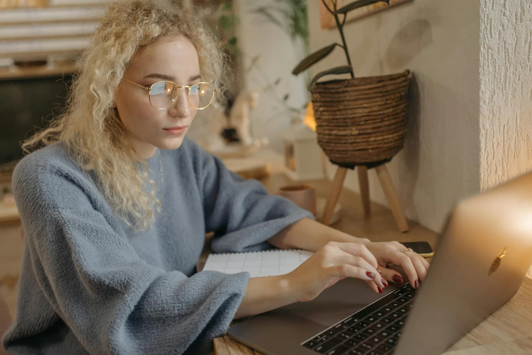 Person tar grep om gjelden ved hjemmekontoret med laptop og papirer